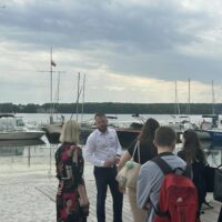 Wyjście z hotelu na plażę wysypaną piaskiem i żwirem oraz do portu żaglówek