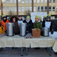 Nauczyciele i uczniowie gotowi do poczęstunku uczestników Orszaku gorącą herbatą