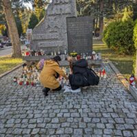 Zapalanie zniczy przed pomnikiem ofiar Katynia 1940