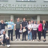 Grupa uczniów naszej szkoły z paniami Agnieszką Zomkowską i Bożeną Lisowską przed budynkiem Zespołu Szkół Budowlanych