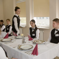 Uczniowie uczący się w zawodzie kelner oraz technik usług kelnerskich przedstawiają zasady prawidłowej obsługi kelnerskiej