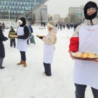 Uczniowie częstują ciasteczkami uczestników Orszaku