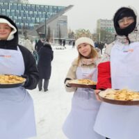 Uczniowie częstują ciasteczkami uczestników Orszaku