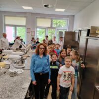 Pani kierownik szkolenia praktycznego Sylwia Olbryś wprowadza dzieci w tajniki pracowni cukierniczej
