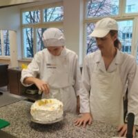 Uczniowie dekorują tort brazylijski