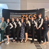 Wspólne zdjęcie nauczycieli i uczniów na tle ścianki ZSGS