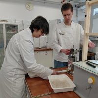 Uczniowie napełniają osłonki masą mięsną