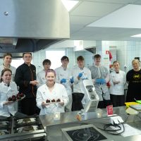 Wspólne zdjęcie uczestników warsztatów cukierniczych z prowadzącymi